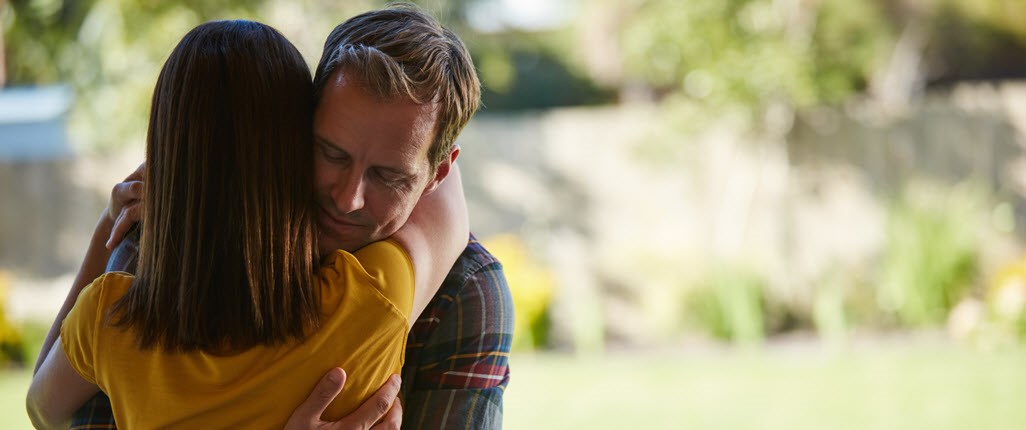 Man and woman hugging at the park