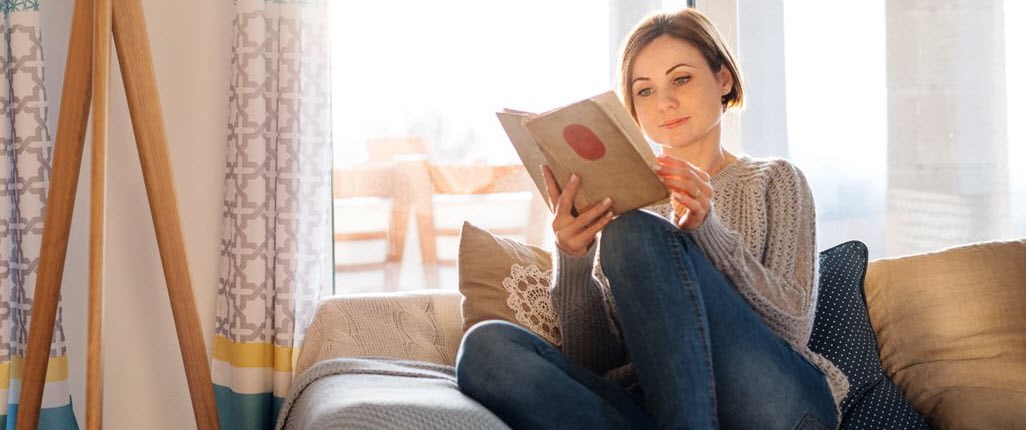 Woman reading a book on the sofa