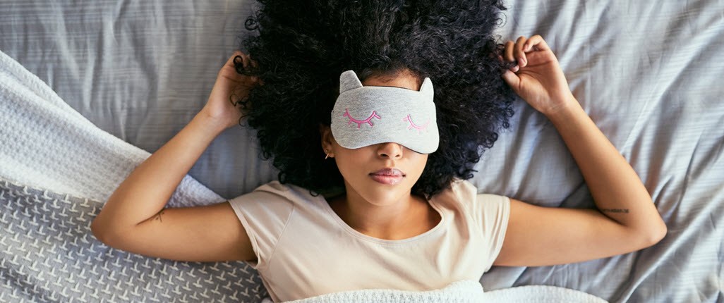 Woman sleeping in the bed with sleeping mask